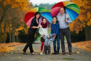 fröhliche Familie mit Regenschirmen